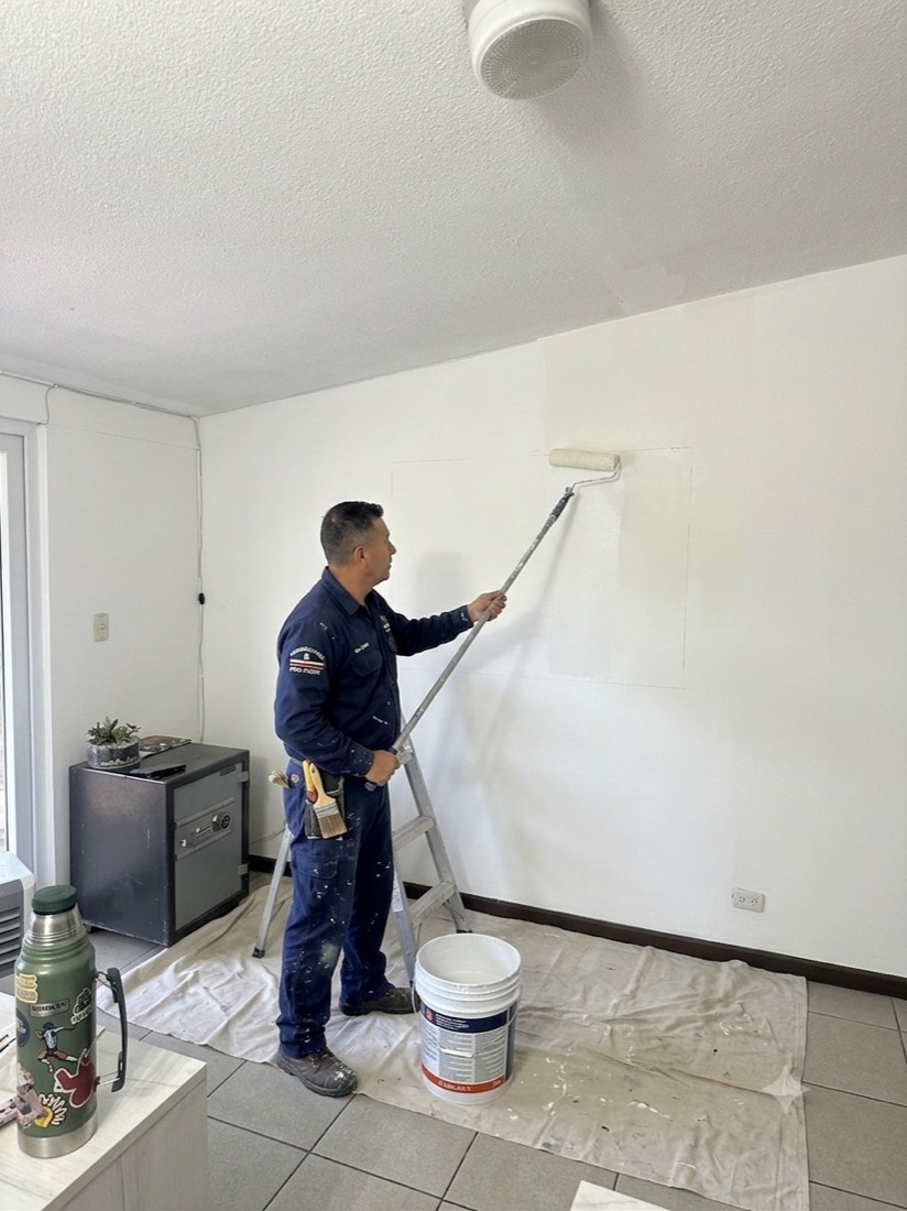 Pintor de Los Pintas pintando una habitación con el piso protegido